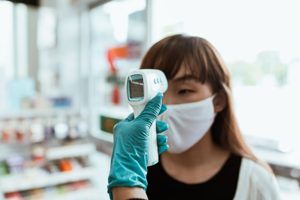 Woman holding digital thermometer.