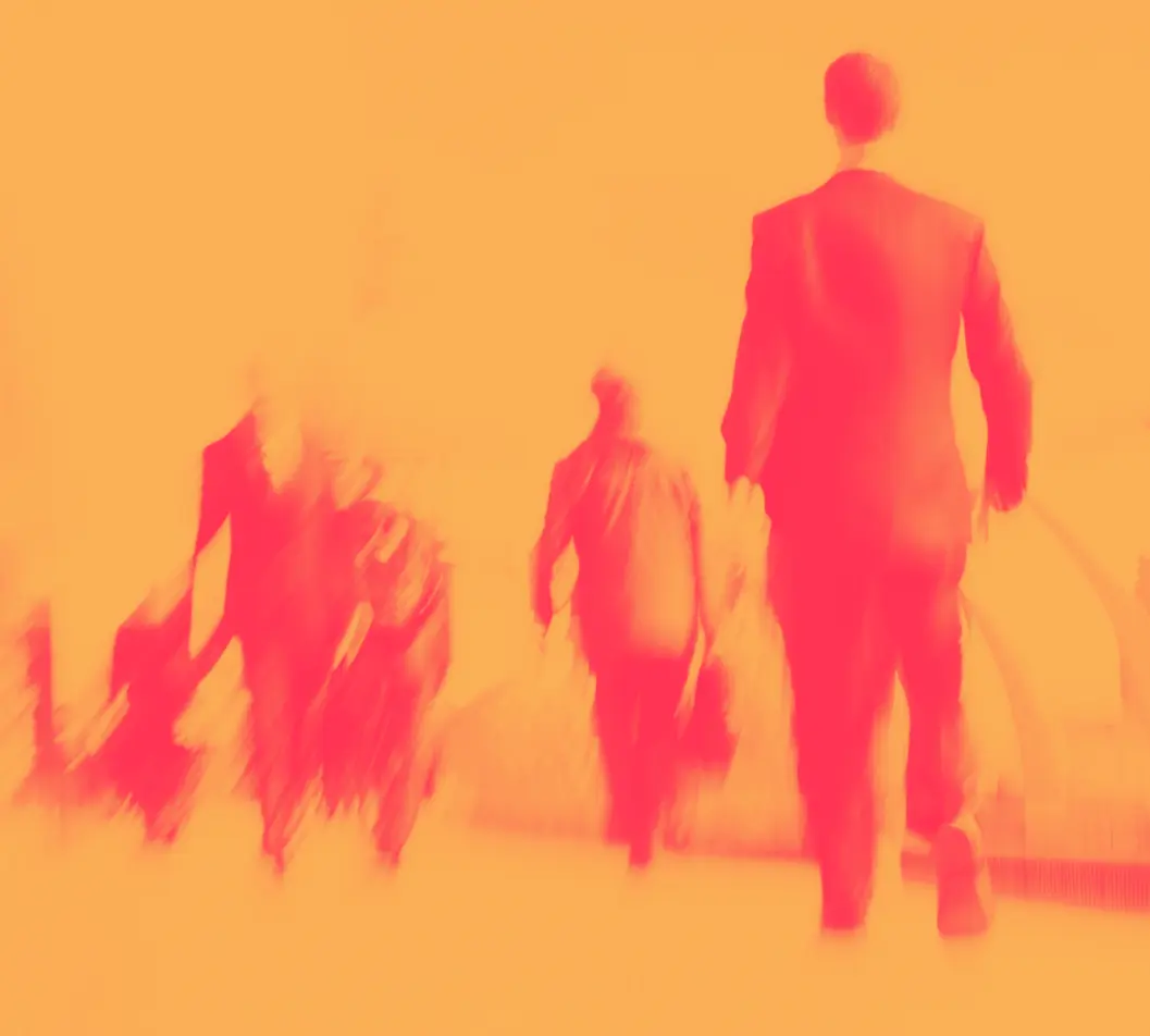 Rush Hour 32x | Whitehouse Communications Blurred pedestrians walking away in an orange-tinted scene, conveying motion in a crowd.