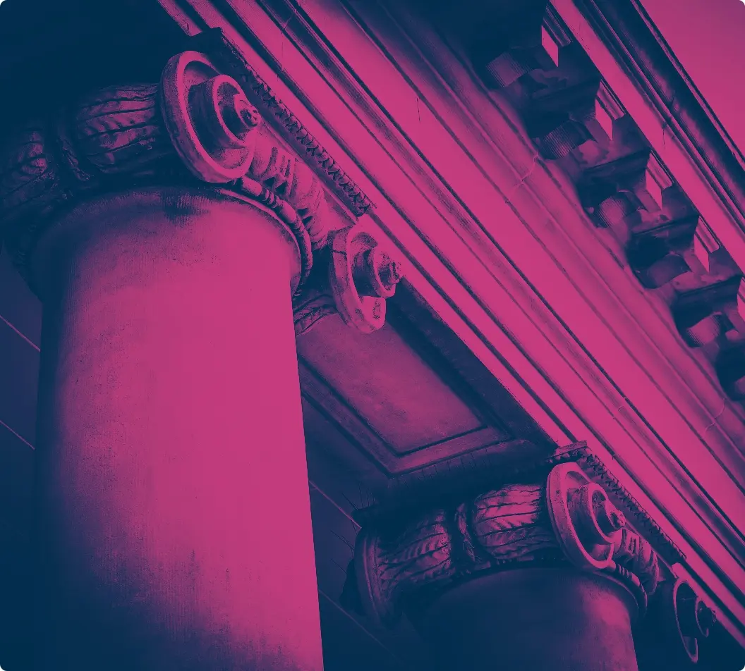 iStock-520623971 copy2x | Whitehouse Communications Close-up of classical columns with decorative capitals, viewed from below in a pink-tinted photo