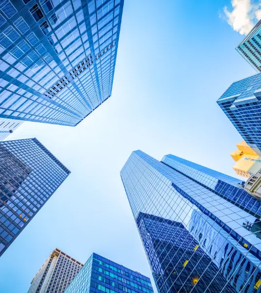 monzo-7470-preview | Whitehouse Communications Skyward view of tall glass skyscrapers forming a square around a bright blue sky.